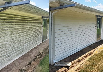Side of white vinyl building before power washing services and after.